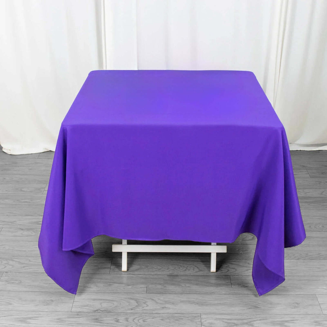 Purple tablecloth draped over a table in a studio setting.