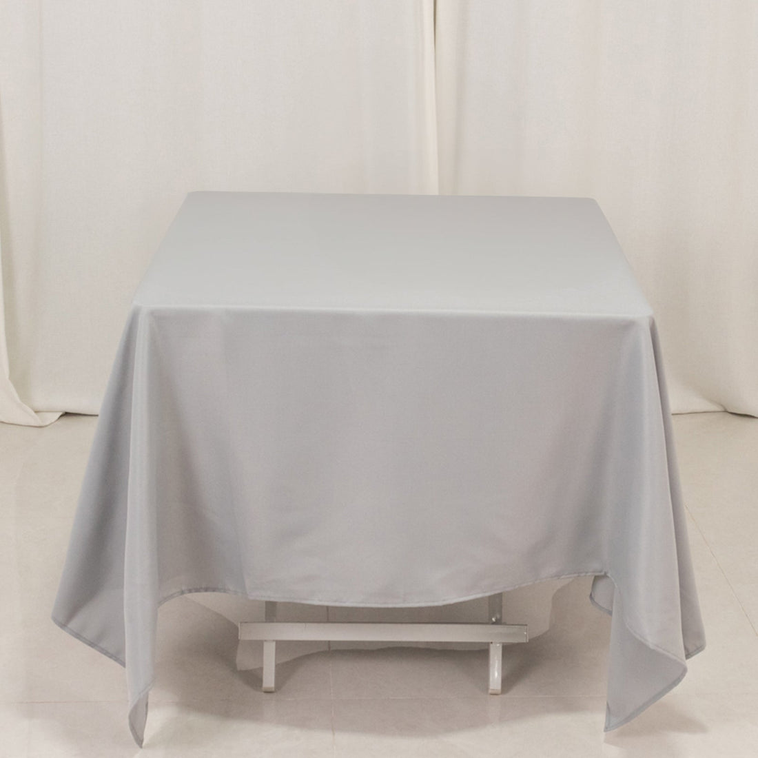 Gray tablecloth draped over a table in a studio setting.