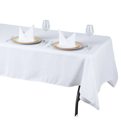 White tablecloth set for elegant dining with napkins and tableware