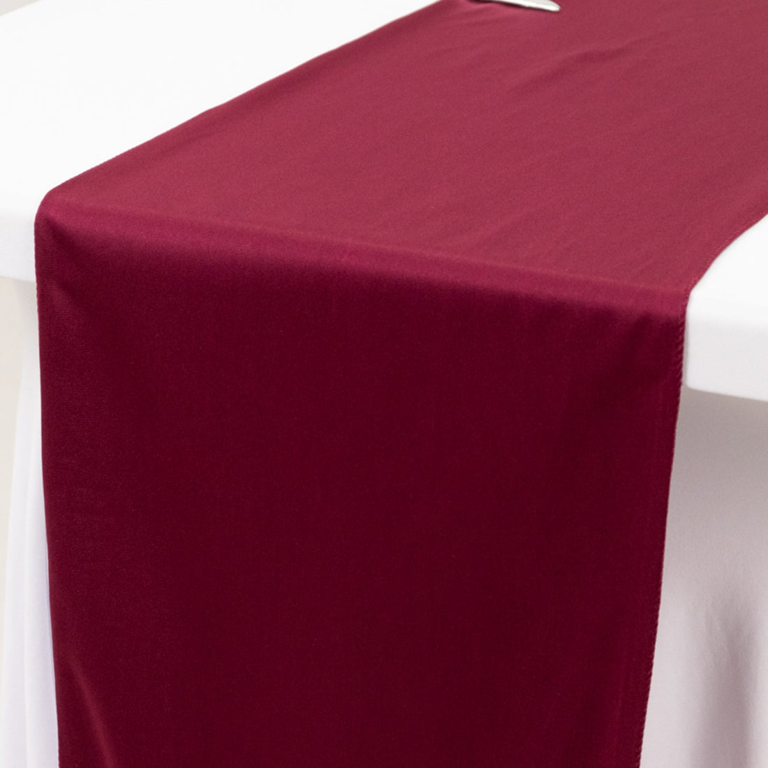 Burgundy table runner on a white table surface