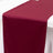 Burgundy table runner on a white table surface