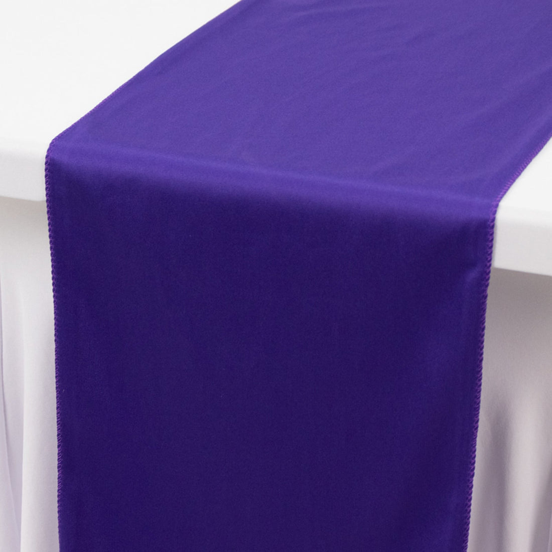 Purple table runner on a white tablecloth