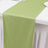 Green table runner on a white table with utensils.