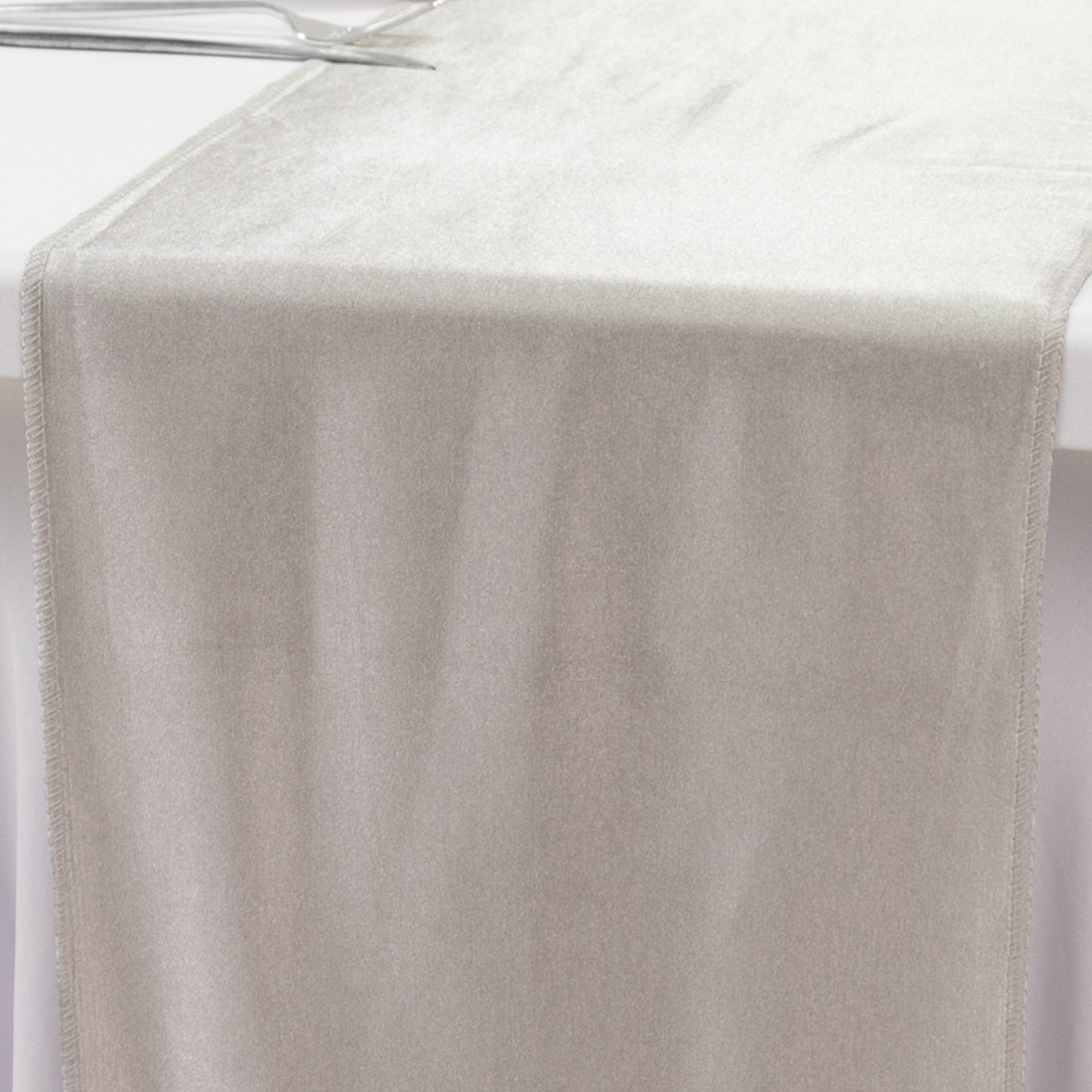 Silky silver table runner on a plain backdrop