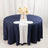 Navy round table with white runner and floral centerpiece in studio setting.