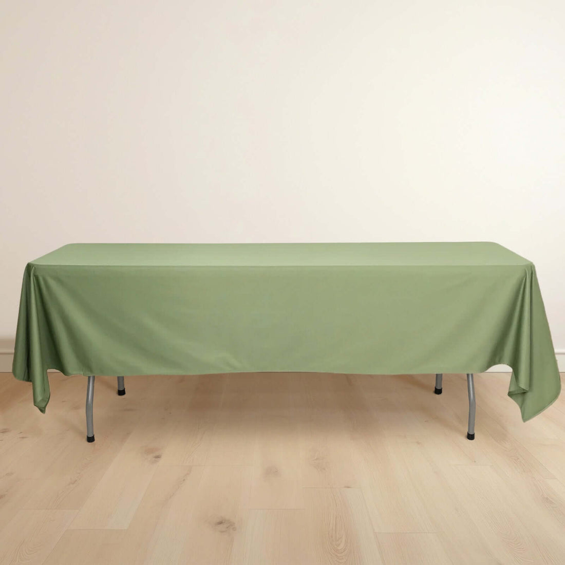 Green tablecloth draped over a folding table on a wooden floor.