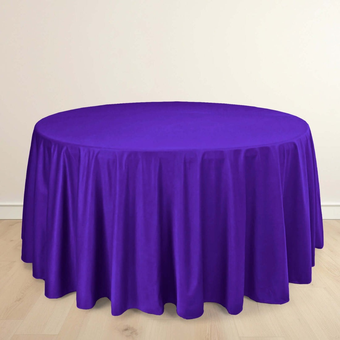 Purple round tablecloth on a light wooden floor.