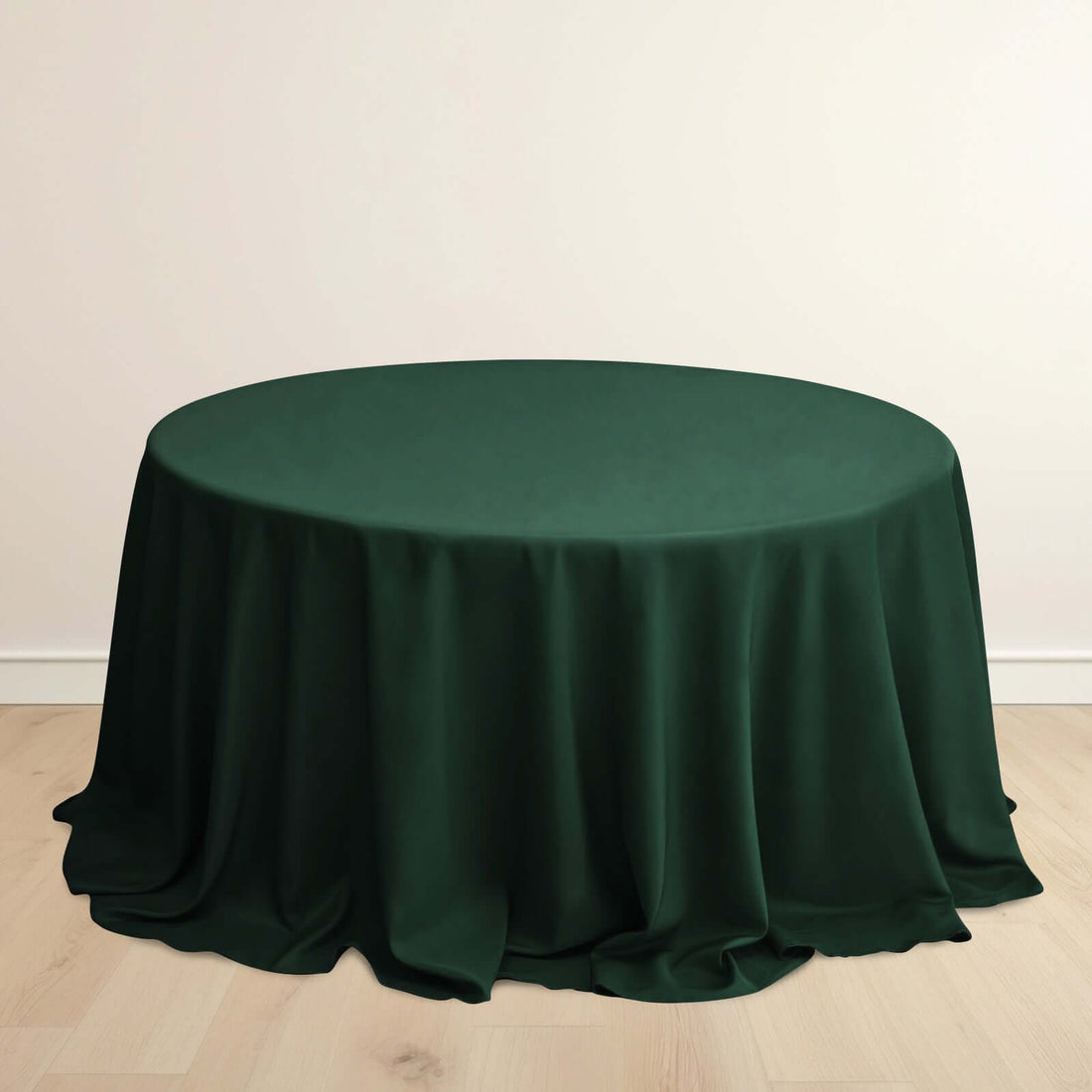 Round green tablecloth on a light wooden floor.