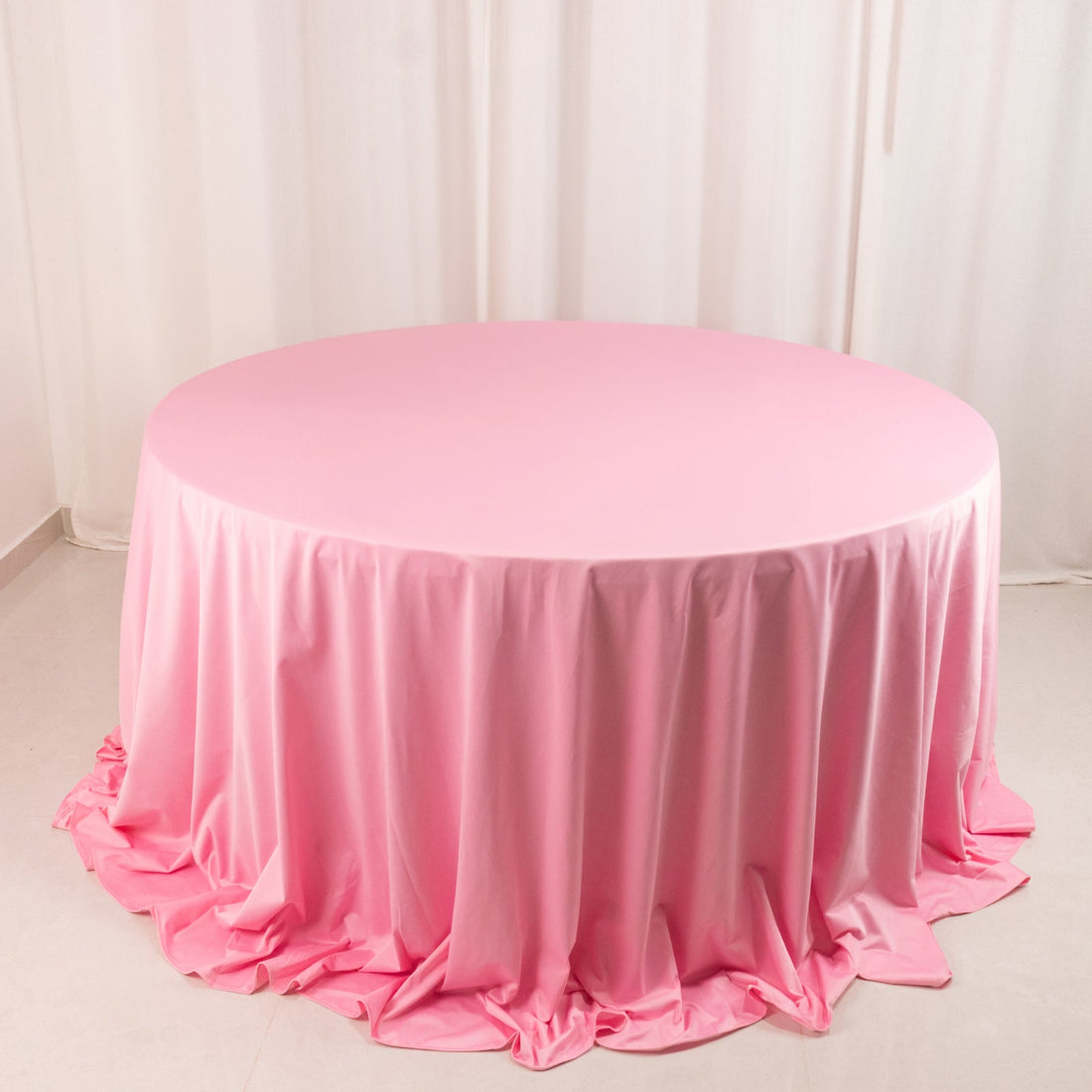 Round pink tablecloth draped elegantly over a circular table