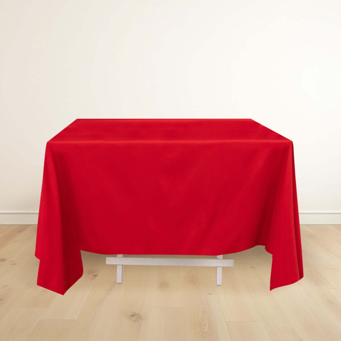 Red tablecloth draped over a white table in a minimalistic setting.