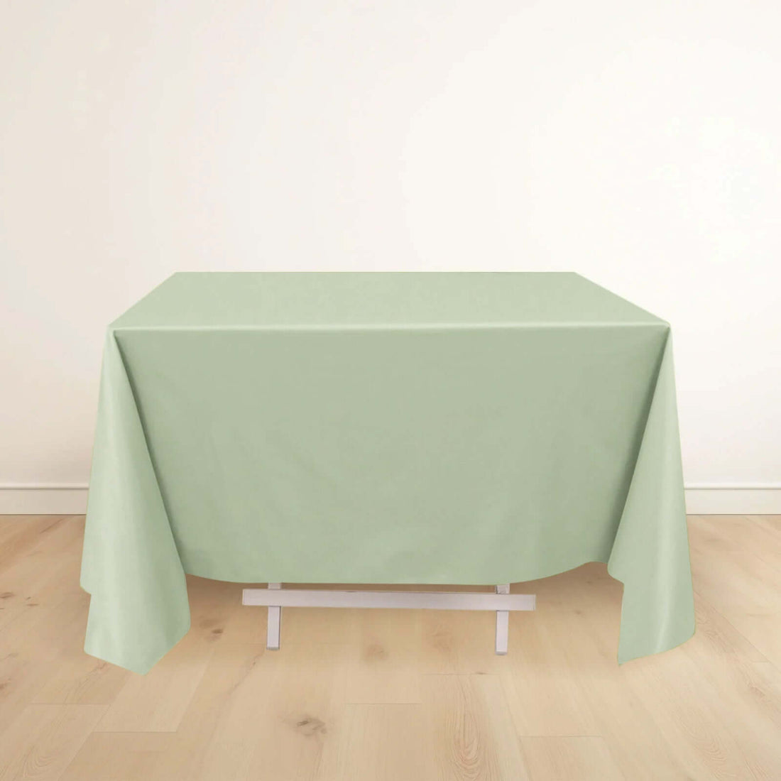 Green tablecloth draped over a table in a minimalist setting.