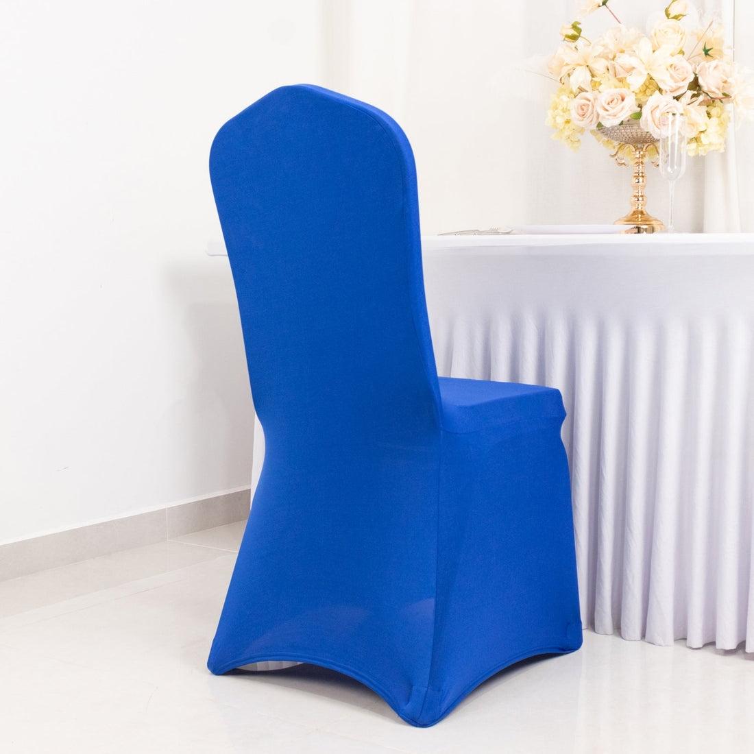 Blue chair cover on a white table in a decorated room.