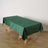 Green tablecloth draped over a wooden table in a minimalistic setting.