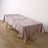 Pink textured tablecloth draped over a wooden table.