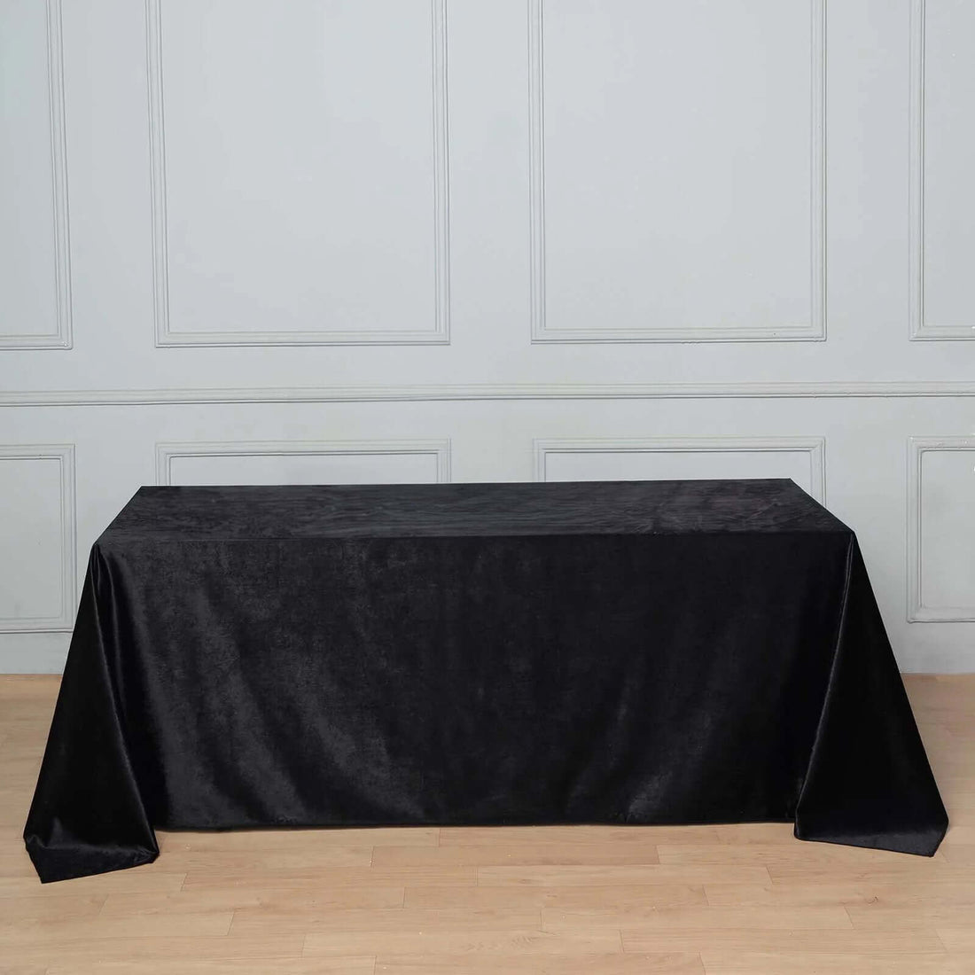 Black tablecloth draped over a rectangular table in a minimalist setting.