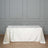 White textured tablecloth draped over a table in a neutral room setting.