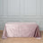 Pink velvet tablecloth on a wooden floor against a gray wall.