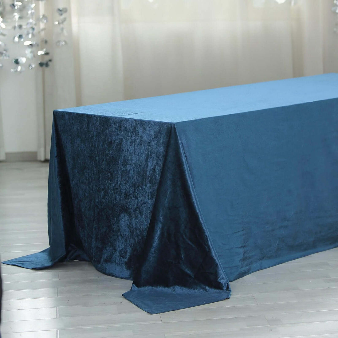Blue velvet tablecloth draped over a table in a bright setting.