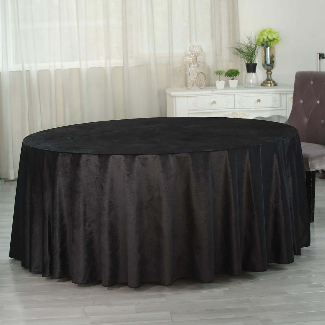 Black round tablecloth draped elegantly over a table in a bright indoor setting.