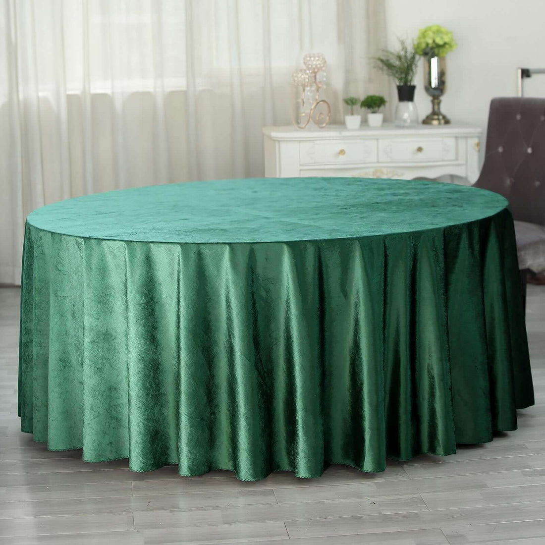 Green round tablecloth draping elegantly over a circular table in a stylish setting.