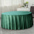 Green round tablecloth draping elegantly over a circular table in a stylish setting.