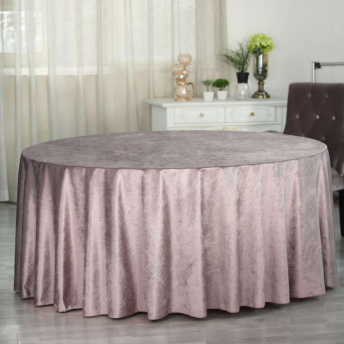 Round table with elegant pink velvet tablecloth in a stylish interior setting.
