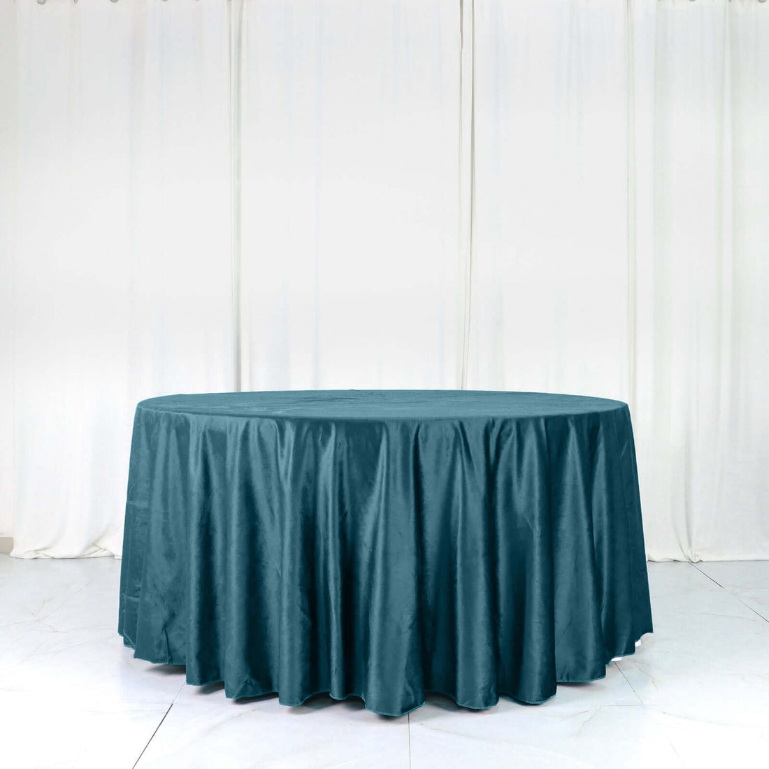 Round teal tablecloth on a plain backdrop