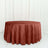 Round rust-colored tablecloth on a plain backdrop.