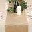 Gold velvet table runner on a dining table with candles and greenery.