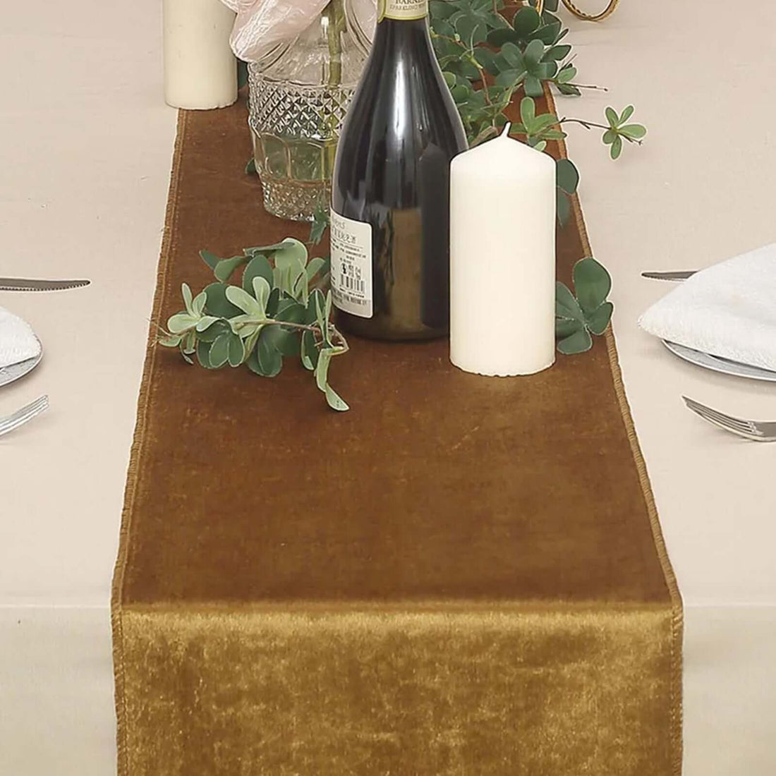 Elegant brown table runner with candles and decorative greenery.