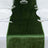 Green velvet table runner on a dining table with white plates and glassware.