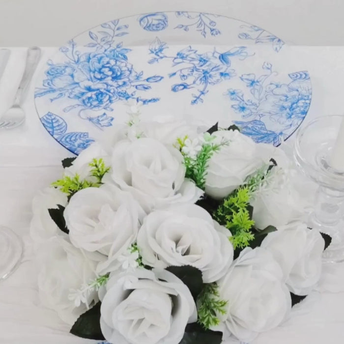 Clear light blue floral charger plate with white roses on a table setting.