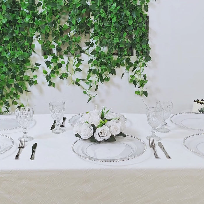 Clear charger plates with silver beaded rim on a decorated table.