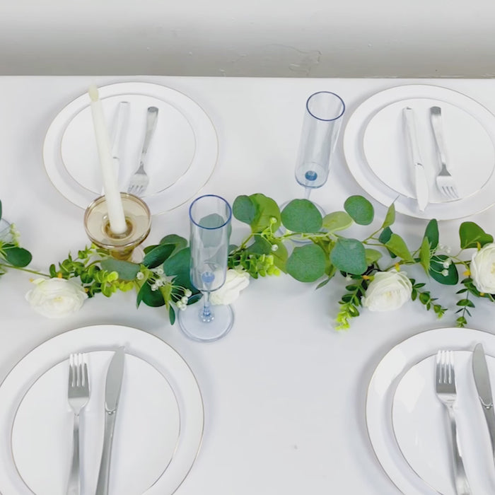 Transparent dusty blue champagne flute glasses on a dining table setting.
