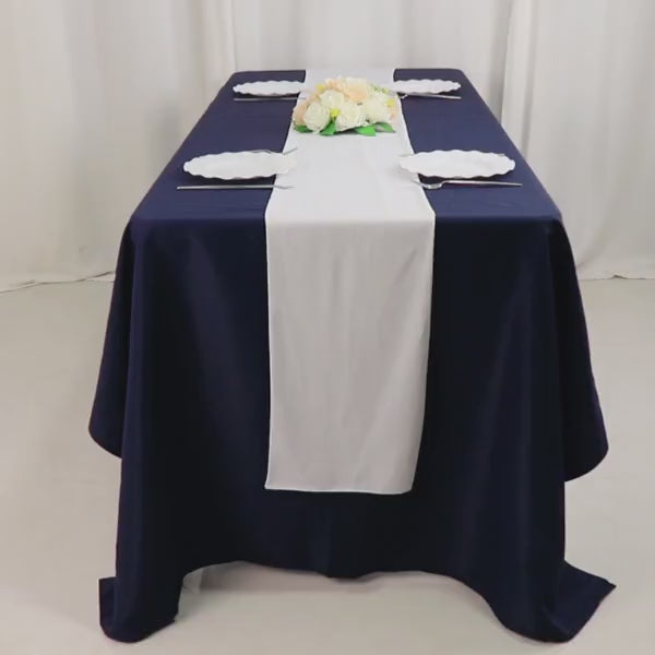 White Scuba Polyester Table Runner on a navy blue table for events and weddings.