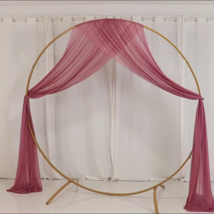 Mauve sheer wedding arch drape with golden frame against a white background.