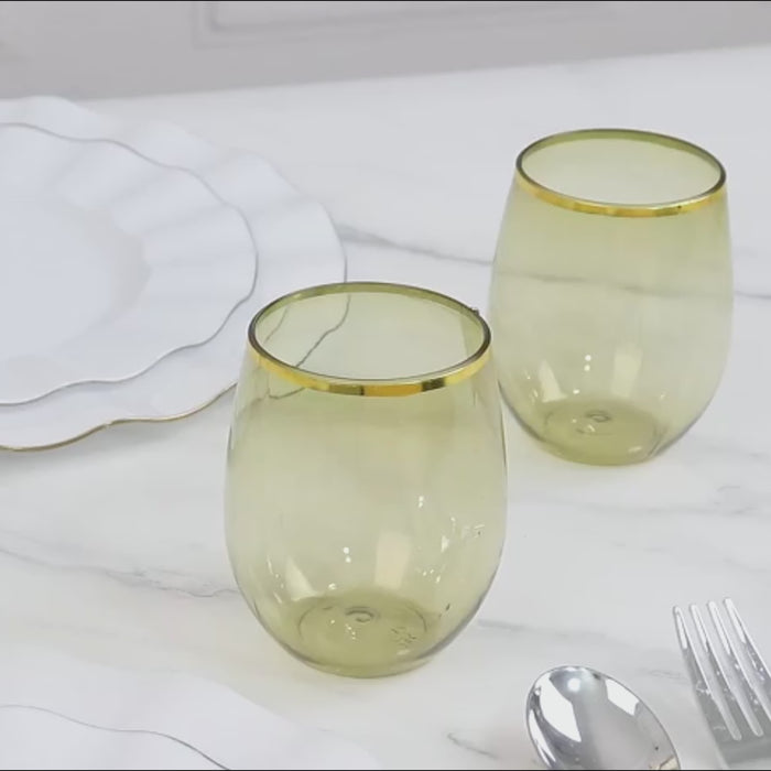 Dusty sage green stemless wine glasses with gold rim on a marble table.