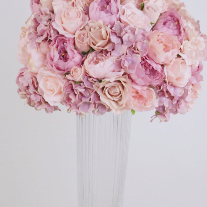 Clear glass ribbed trumpet vase with pink floral arrangement.