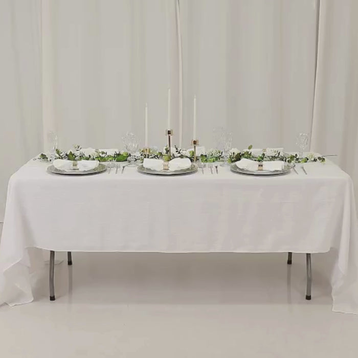 Silver beaded rim charger plates on a white table setting.