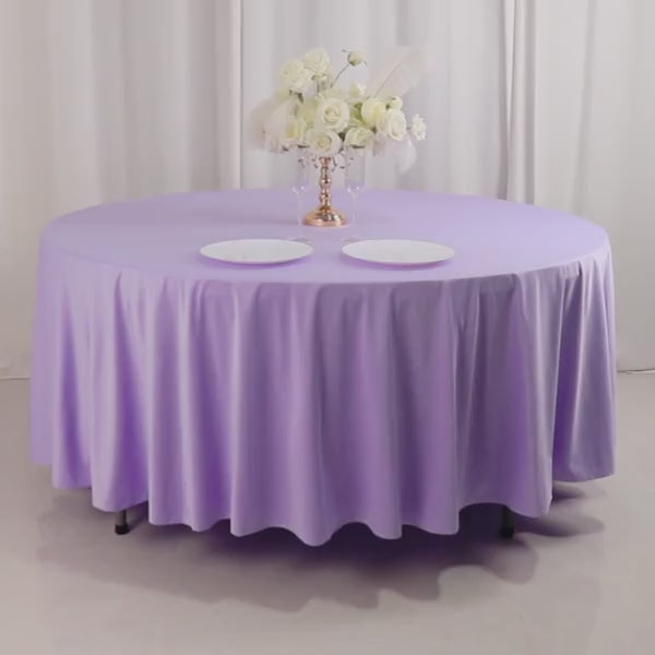 Lavender lilac round tablecloth with elegant draping and white plates.