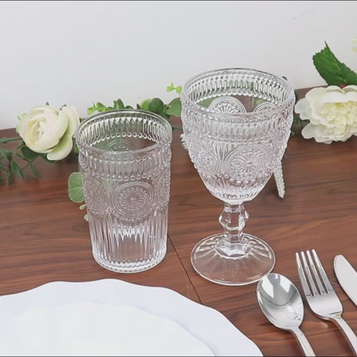 Clear floral pattern vintage embossed glass goblets on a wooden table.