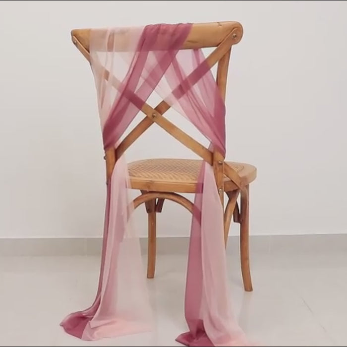 Mauve blush sheer chair sash draped on a wooden chair.