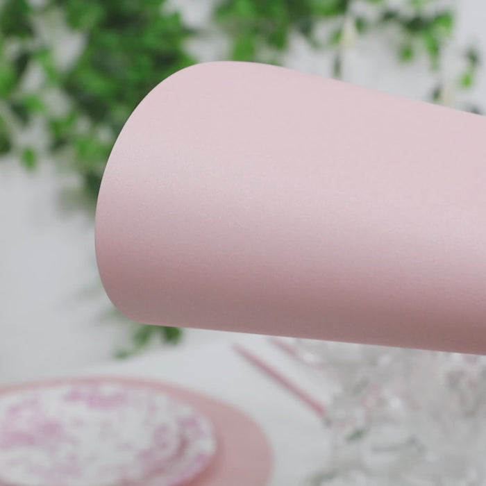 Pink disposable paper placemats in a round shape for dining tables.
