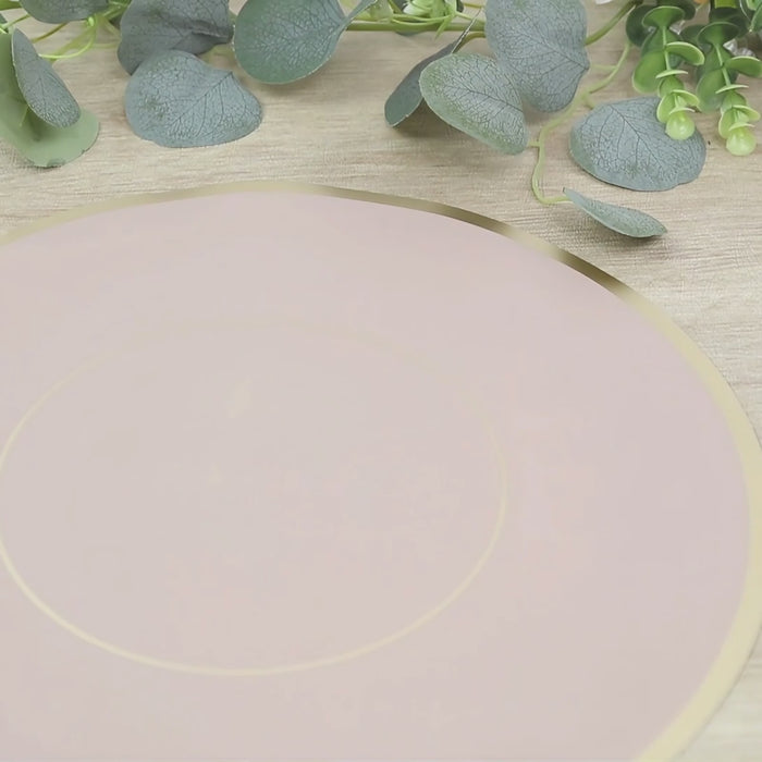 Dusty rose round placemat with gold rim on a wooden table surface.