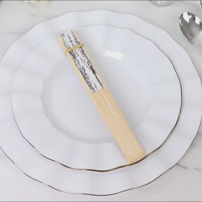 White handheld folding fans with black French toile pattern on a bamboo frame.