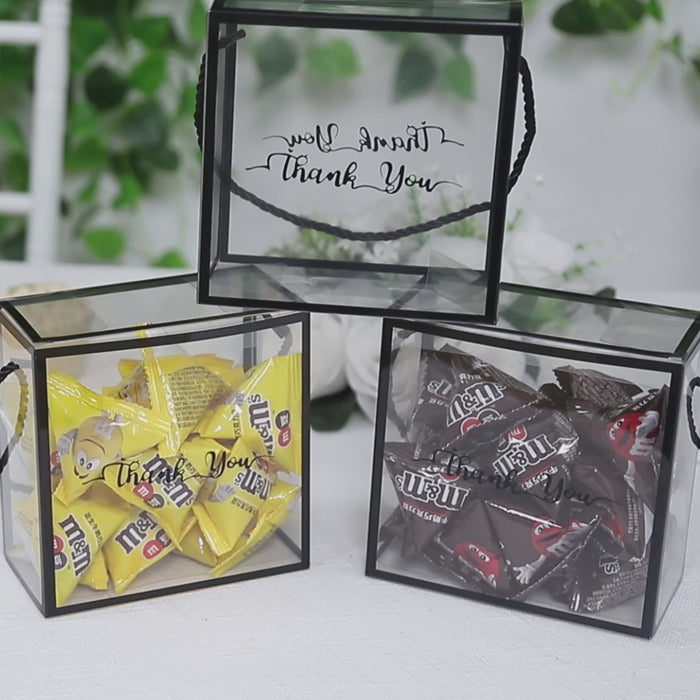 Clear PVC favor boxes with black trim, filled with candy and "Thank You" print.