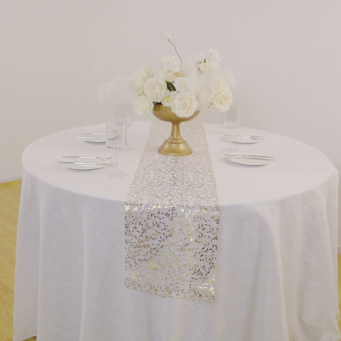 White organza table runner with gold foil leaf vines on a round table setting.