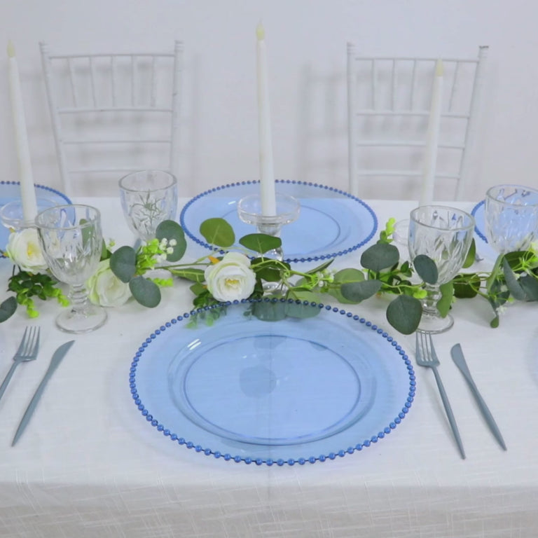 Dusty blue beaded rim charger plates on a decorated dinner table.