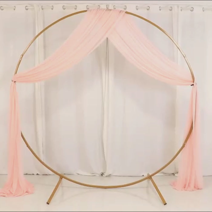 Blush sheer wedding arch drape with elegant fabric cascading down.