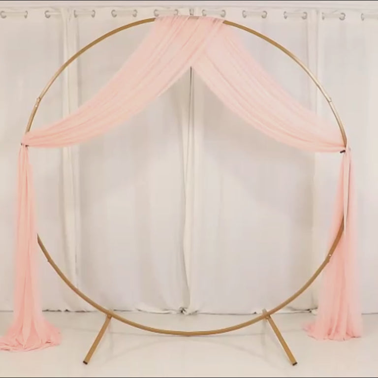 Blush sheer wedding arch drape with elegant fabric cascading down.